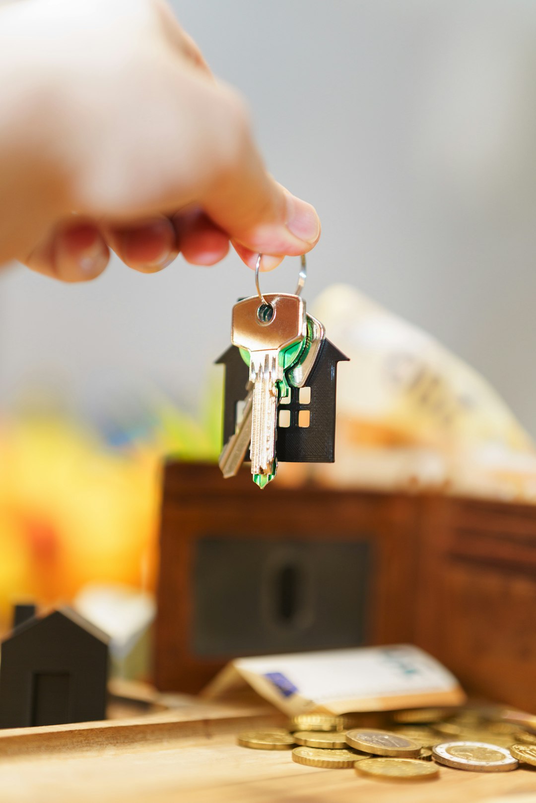 Home hand holding new house door keys wallet money price real estate market