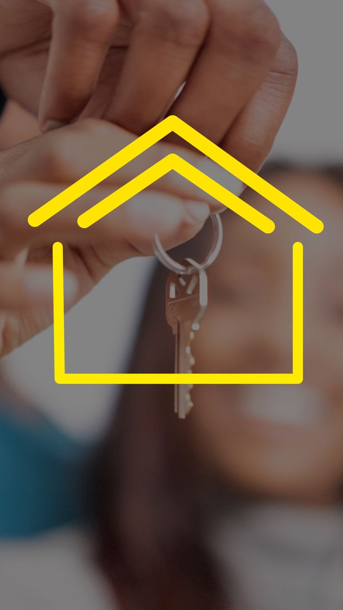 Home Close-up of hands holding house keys with yellow house icon overlay, representing real estate.